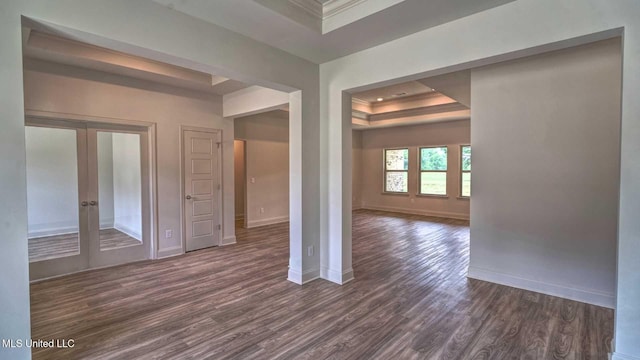 spare room featuring baseboards, dark wood-style floors, a raised ceiling, french doors, and crown molding