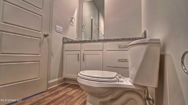 bathroom featuring wood finished floors, vanity, and baseboards