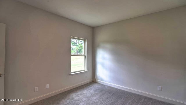 unfurnished room featuring carpet floors and baseboards