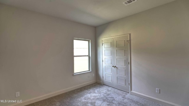 unfurnished bedroom featuring visible vents, carpet floors, and baseboards