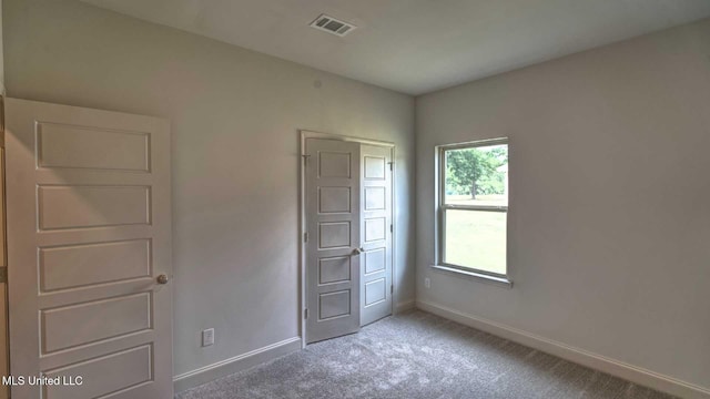 unfurnished bedroom featuring carpet, visible vents, and baseboards