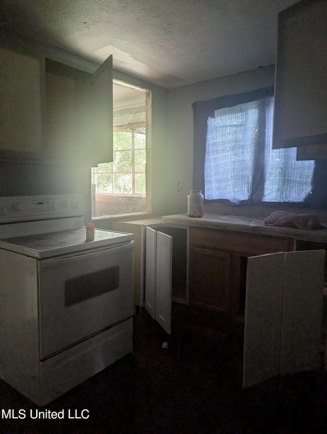 kitchen featuring white stove and a textured ceiling