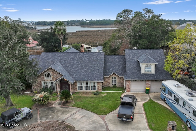 view of front of property featuring a water view, a front yard, and a garage