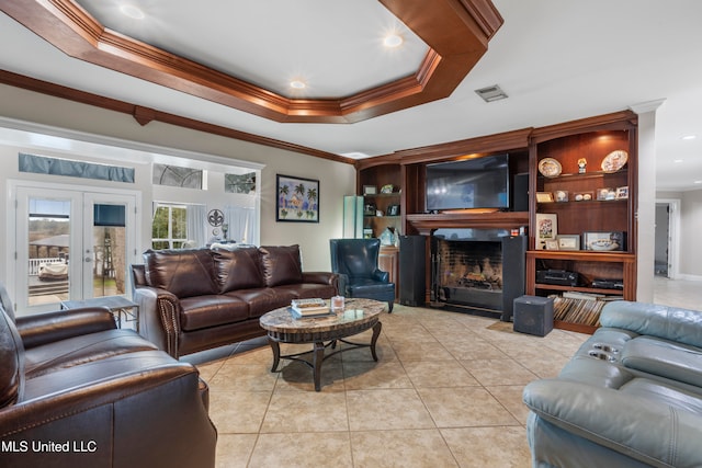 living room featuring a raised ceiling, crown molding, french doors, and light tile patterned flooring