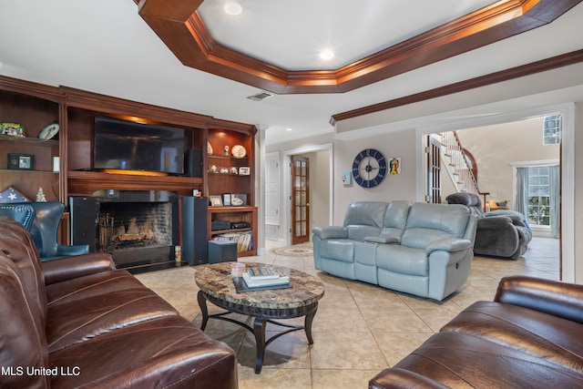 tiled living room with a tray ceiling and crown molding