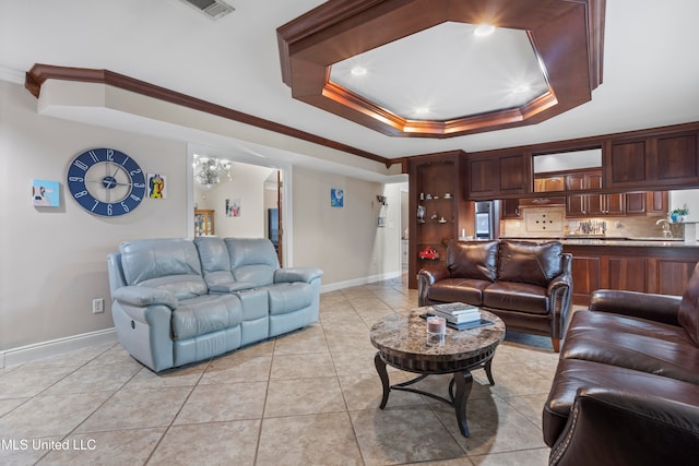 tiled living room featuring a tray ceiling, sink, and ornamental molding