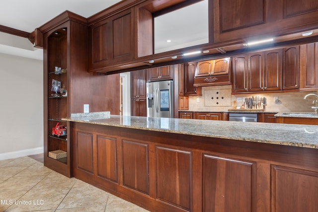 kitchen featuring sink, tasteful backsplash, light tile patterned flooring, light stone counters, and stainless steel appliances