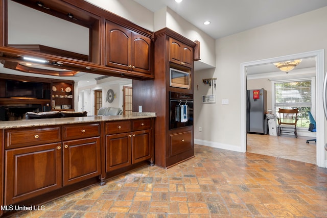 kitchen with light stone counters, crown molding, and appliances with stainless steel finishes