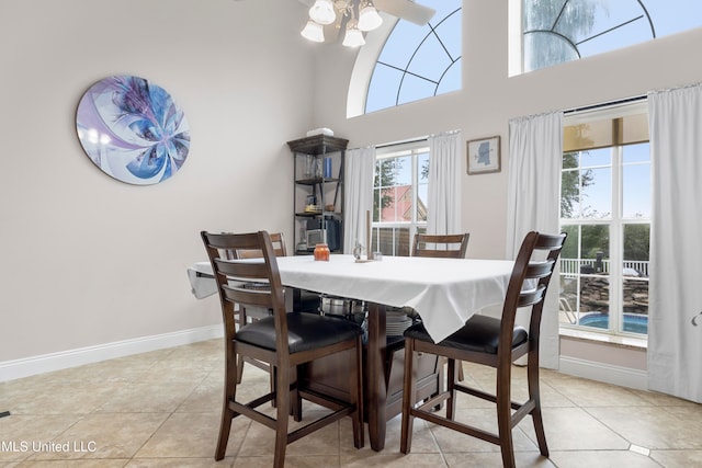 tiled dining area with a high ceiling, ceiling fan, and a healthy amount of sunlight