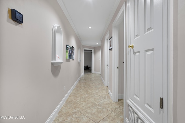 hall with ornamental molding and light tile patterned floors