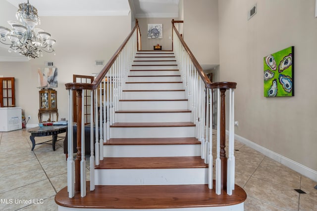 staircase with tile patterned flooring, a high ceiling, ornamental molding, and a notable chandelier