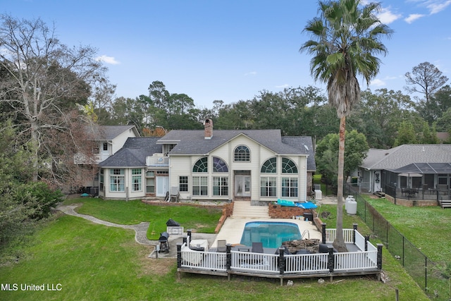 rear view of house with outdoor lounge area, a fenced in pool, and a yard