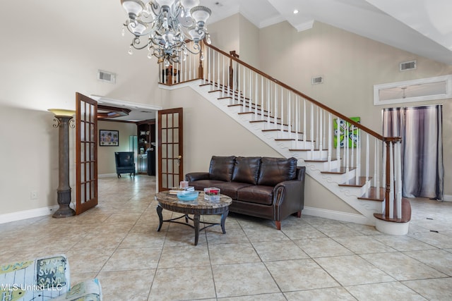 living room with french doors, an inviting chandelier, a towering ceiling, ornamental molding, and light tile patterned floors