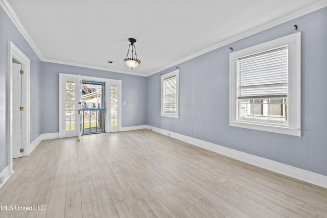 empty room with visible vents, baseboards, ornamental molding, and light wood finished floors