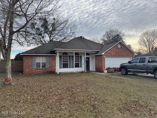 ranch-style home with brick siding, roof with shingles, fence, a garage, and a front lawn