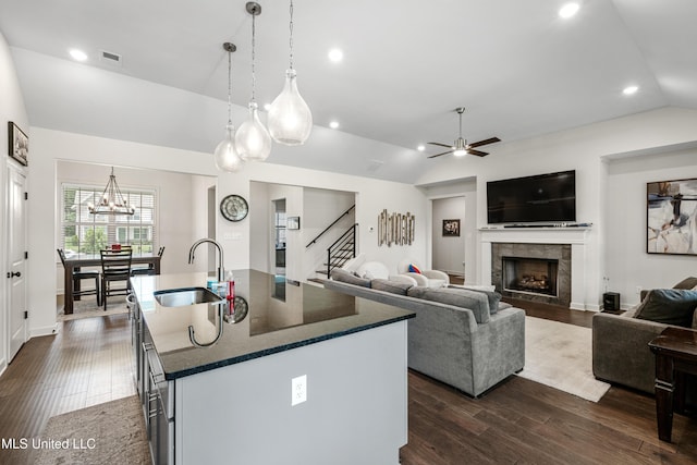 4432 John Wood Ln, Olive Branch, MS 38654 - kitchen with lofted ceiling, a tiled fireplace, dark wood-type flooring, ceiling fan, and a kitchen island with sink