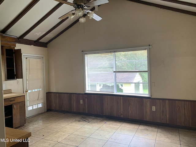 unfurnished room with high vaulted ceiling, wood walls, and beamed ceiling