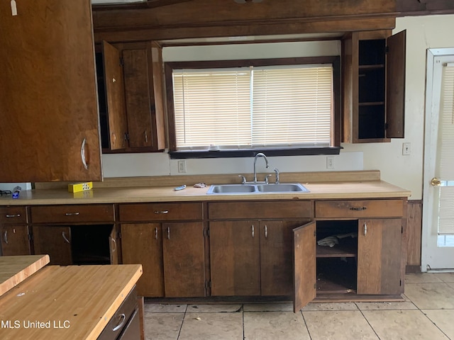 kitchen with sink, dark brown cabinets, and light tile patterned floors