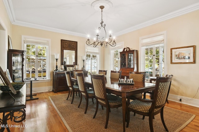 600 N Beach Blvd, Bay Saint Louis, MS 39520 - dining room featuring plenty of natural light, a chandelier, light wood finished floors, and ornamental molding