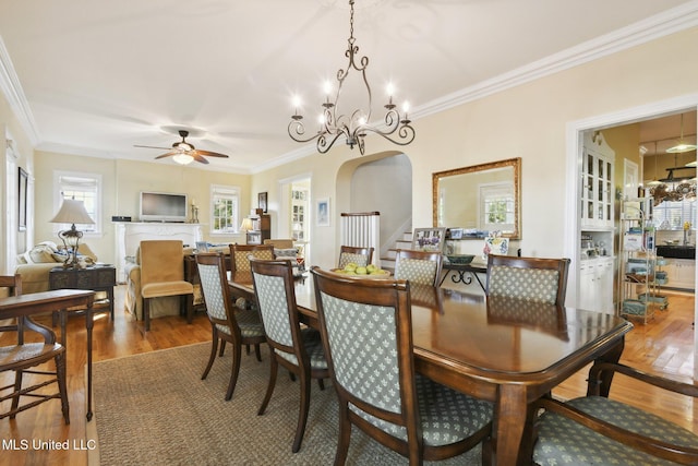 600 N Beach Blvd, Bay Saint Louis, MS 39520 - dining room featuring wood finished floors, crown molding, a ceiling fan, arched walkways, and stairway
