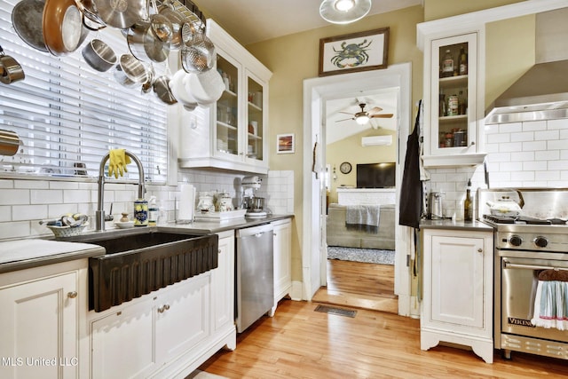600 N Beach Blvd, Bay Saint Louis, MS 39520 - kitchen featuring appliances with stainless steel finishes, wall chimney exhaust hood, and tasteful backsplash