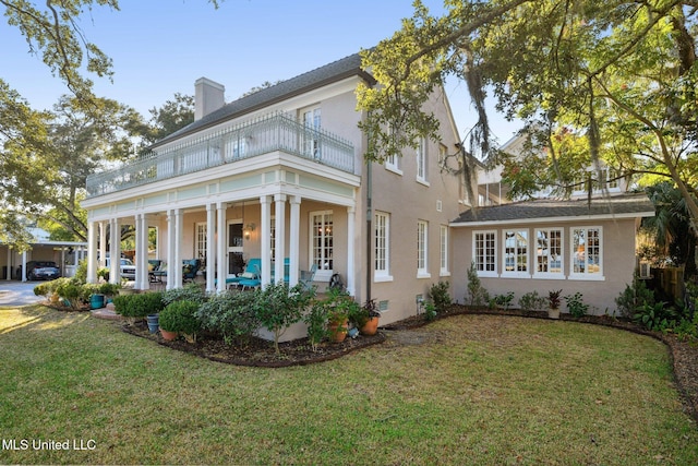 600 N Beach Blvd, Bay Saint Louis, MS 39520 - rear view of property featuring a balcony, a lawn, and stucco siding