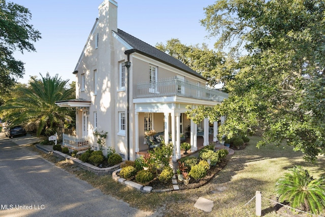 600 N Beach Blvd, Bay Saint Louis, MS 39520 - view of side of home with a balcony, a chimney, and stucco siding