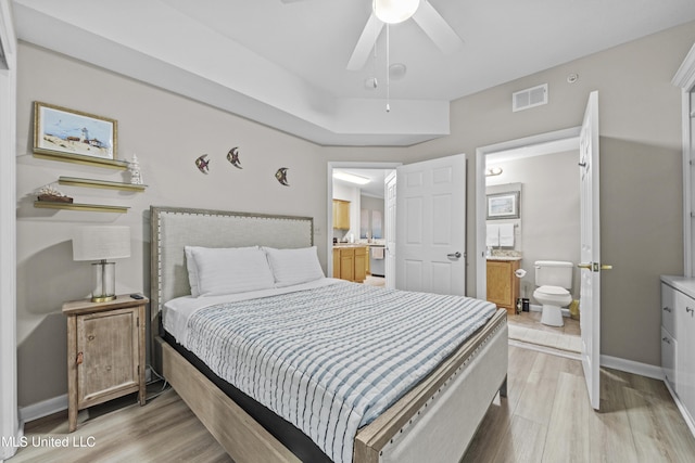 bedroom with baseboards, connected bathroom, light wood finished floors, and visible vents