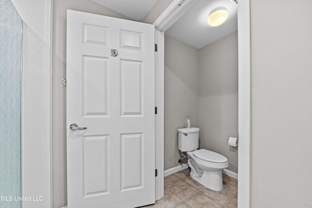 bathroom with tile patterned floors, baseboards, and toilet