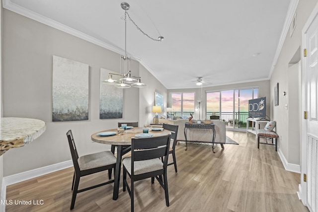 dining area featuring crown molding, baseboards, ceiling fan, and light wood-style flooring
