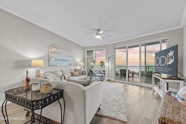 living room with baseboards, ornamental molding, a ceiling fan, and wood finished floors