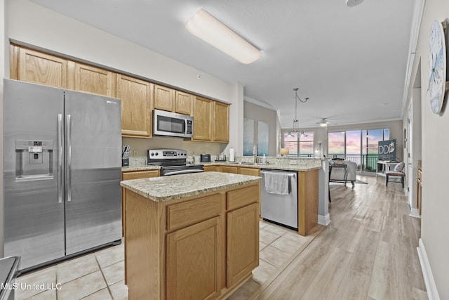 kitchen with a center island, light stone countertops, a peninsula, ornamental molding, and stainless steel appliances