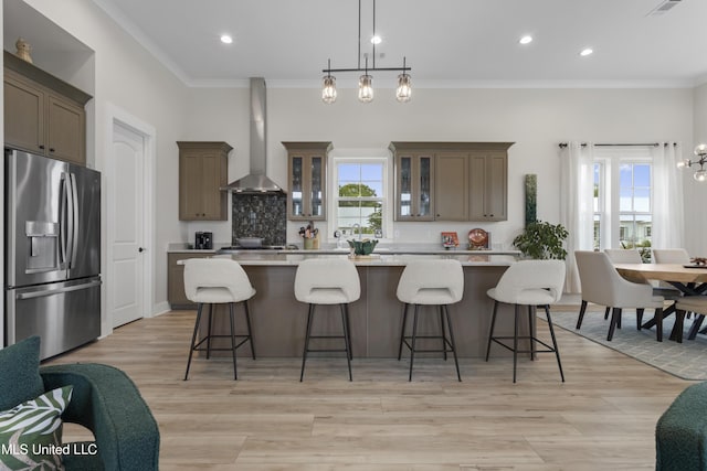 435 Bills Ave, Ocean Springs, MS 39564 - kitchen with appliances with stainless steel finishes, wall chimney range hood, crown molding, a large island, and light countertops
