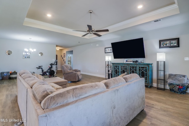 11458 Leann Ct, Ocean Springs, MS 39564 - living area with a tray ceiling, wood finished floors, crown molding, ceiling fan, and a chandelier