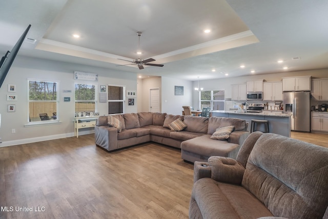 11458 Leann Ct, Ocean Springs, MS 39564 - living area with a raised ceiling, ceiling fan, light wood-type flooring, baseboards, and crown molding