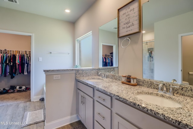 11458 Leann Ct, Ocean Springs, MS 39564 - bathroom featuring a spacious closet, tiled shower, wood finished floors, double vanity, and toilet