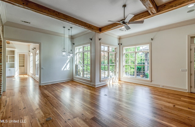 unfurnished living room with beamed ceiling, hardwood / wood-style flooring, and plenty of natural light