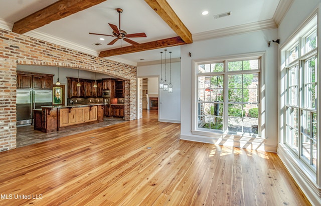 unfurnished living room with beam ceiling, light hardwood / wood-style flooring, brick wall, crown molding, and ceiling fan