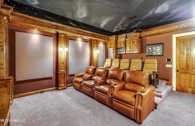 carpeted home theater room featuring crown molding