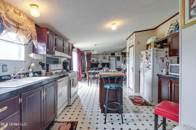 kitchen featuring crown molding, a textured ceiling, sink, and white appliances