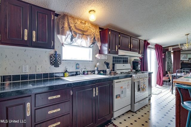 kitchen featuring white appliances, a textured ceiling, and sink
