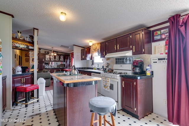 kitchen featuring lofted ceiling, a kitchen island, a textured ceiling, sink, and white appliances