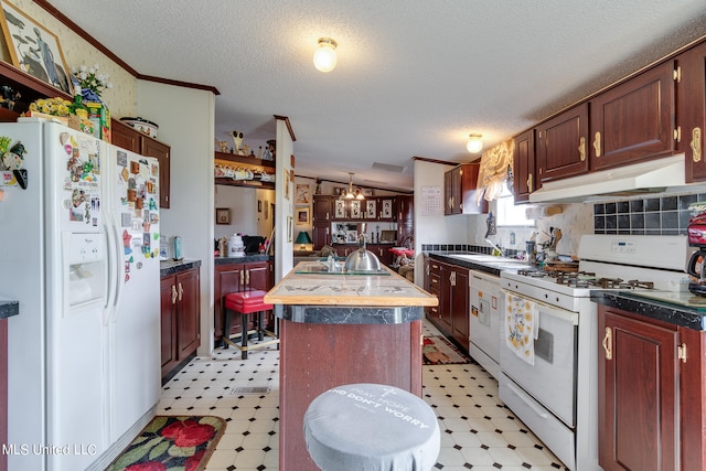 kitchen with crown molding, a textured ceiling, a kitchen island with sink, and white appliances