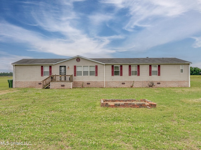 view of front of house with an outdoor fire pit and a front lawn