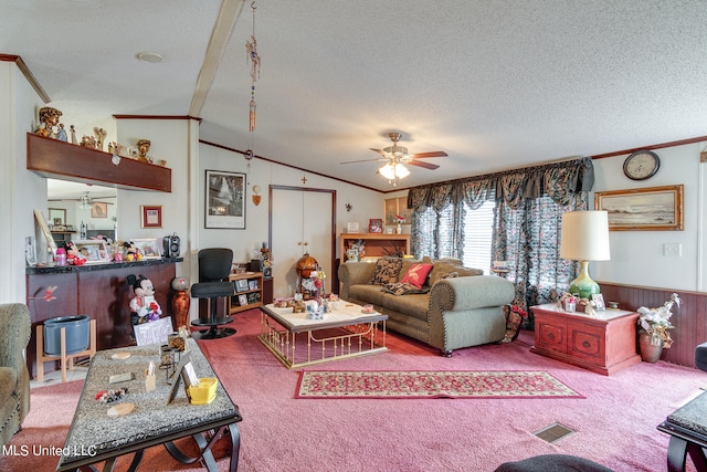 living room featuring lofted ceiling, ceiling fan, a textured ceiling, carpet flooring, and wood walls