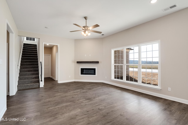 unfurnished living room featuring ceiling fan and dark hardwood / wood-style floors