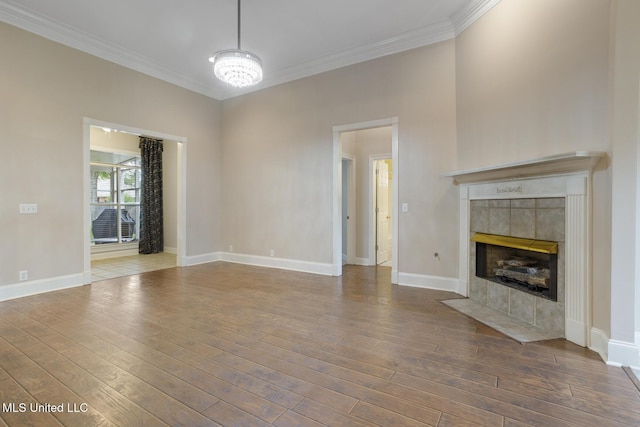 504 Carlisle Cir, Madison, MS 39110 - unfurnished living room featuring ornamental molding, hardwood / wood-style floors, a tile fireplace, and a chandelier