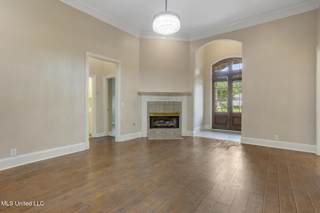 504 Carlisle Cir, Madison, MS 39110 - unfurnished living room featuring arched walkways, crown molding, a tiled fireplace, hardwood / wood-style flooring, and a chandelier