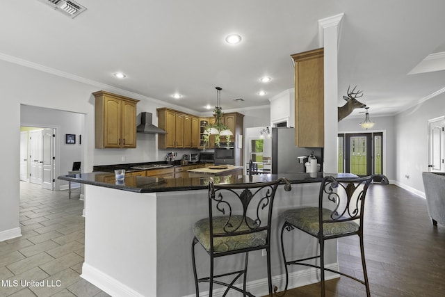 8185 Ridgewood Dr, Kiln, MS 39556 - kitchen with appliances with stainless steel finishes, wall chimney range hood, recessed lighting, a peninsula, and baseboards