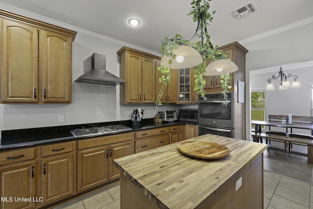 8185 Ridgewood Dr, Kiln, MS 39556 - kitchen with wall chimney exhaust hood, butcher block countertops, stainless steel appliances, light tile patterned floors, and crown molding